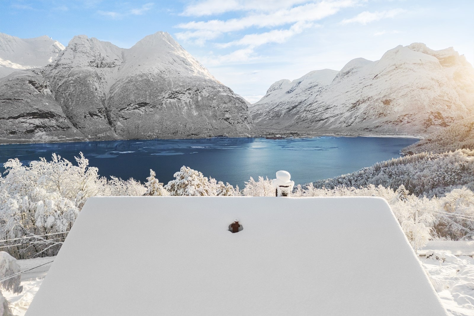 Dronebilde fra østsiden av huset, som viser den unike beliggenheten og utsikten. Galleribilde