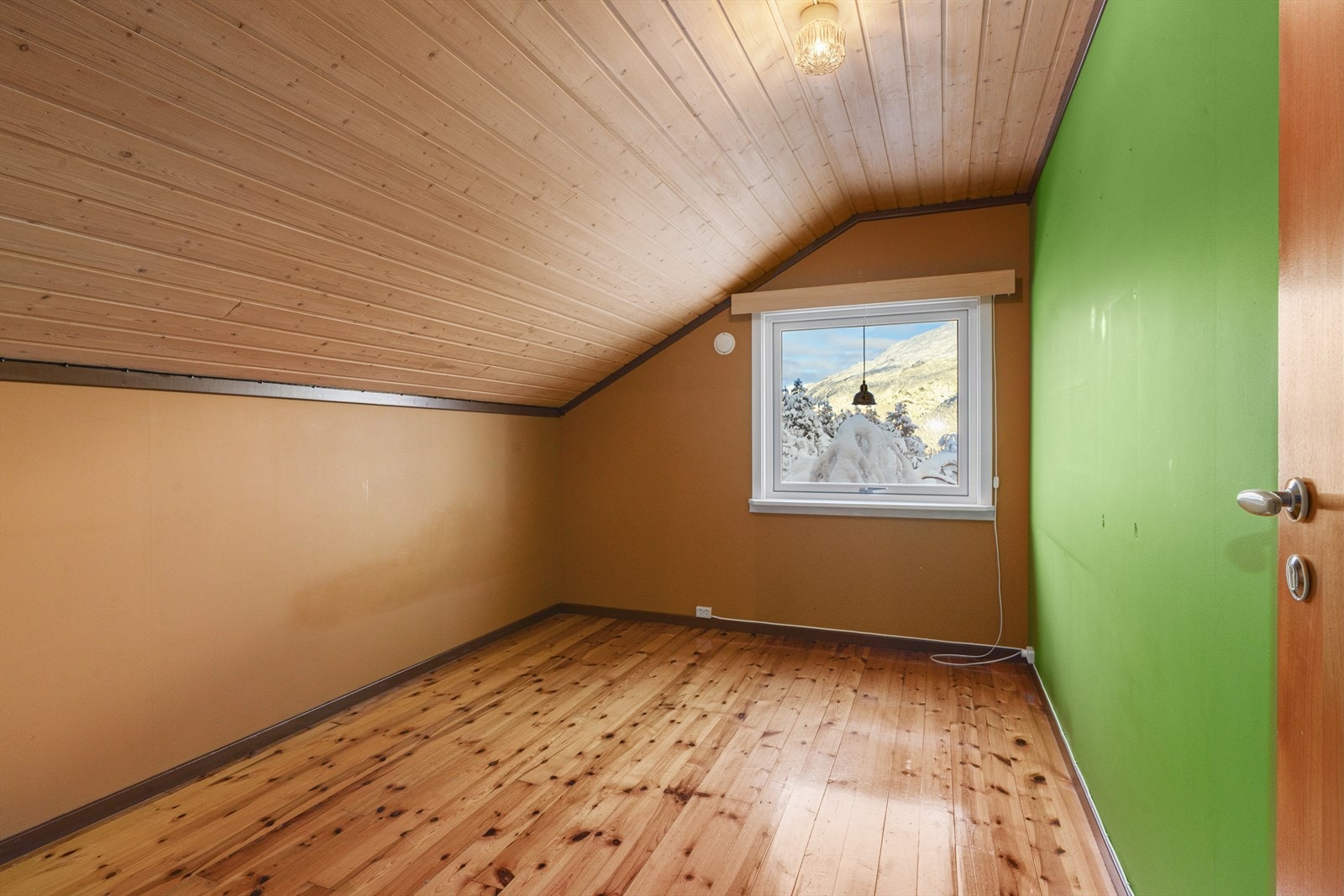 Furugulv og panel i himlingen gir et varmt og naturlig preg til rommet. Galleribilde