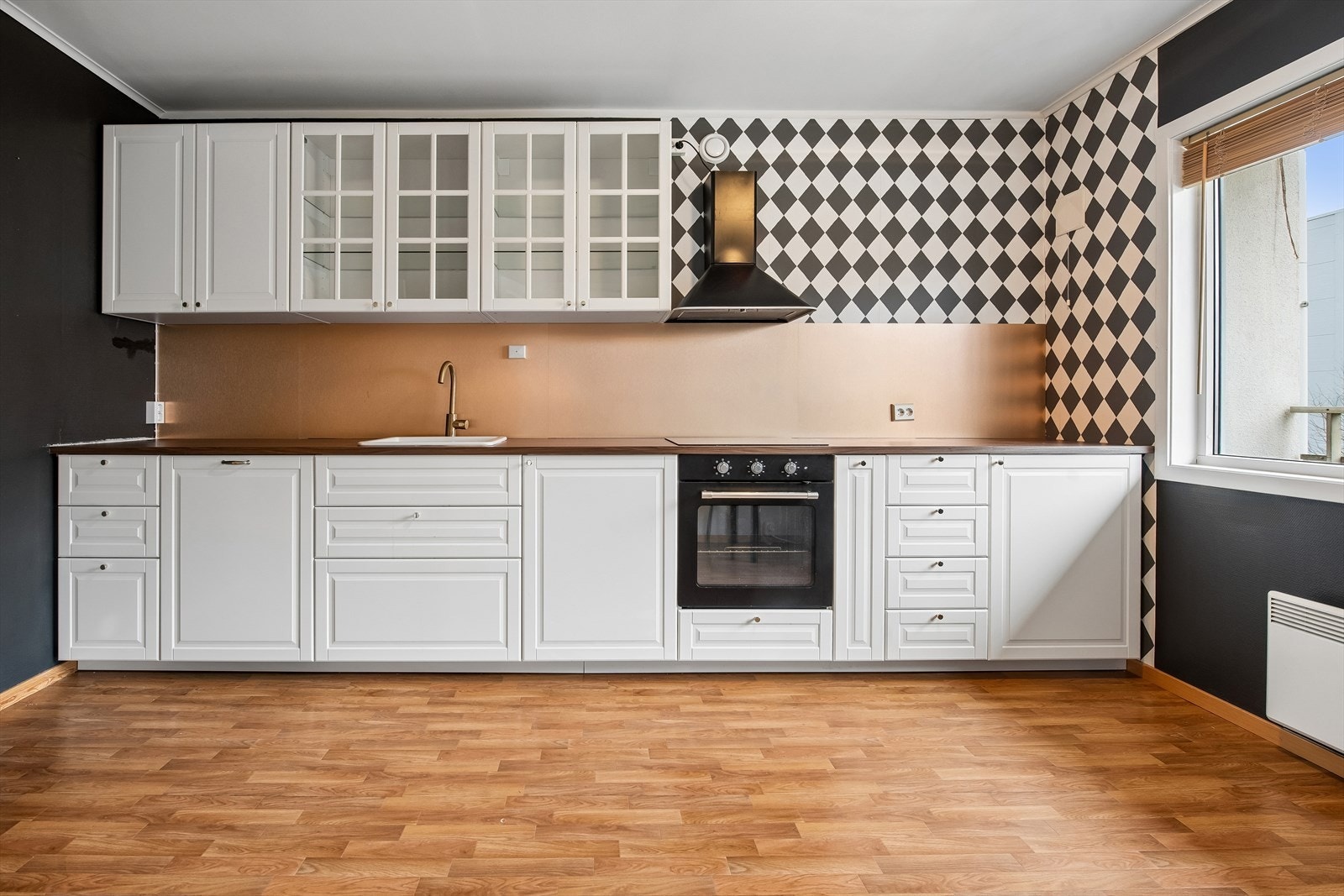 Kjøkkeninnredningen har profilerte fronter, laminatbenkeplate og integrert induksjonstopp og stekeovn. Galleribilde