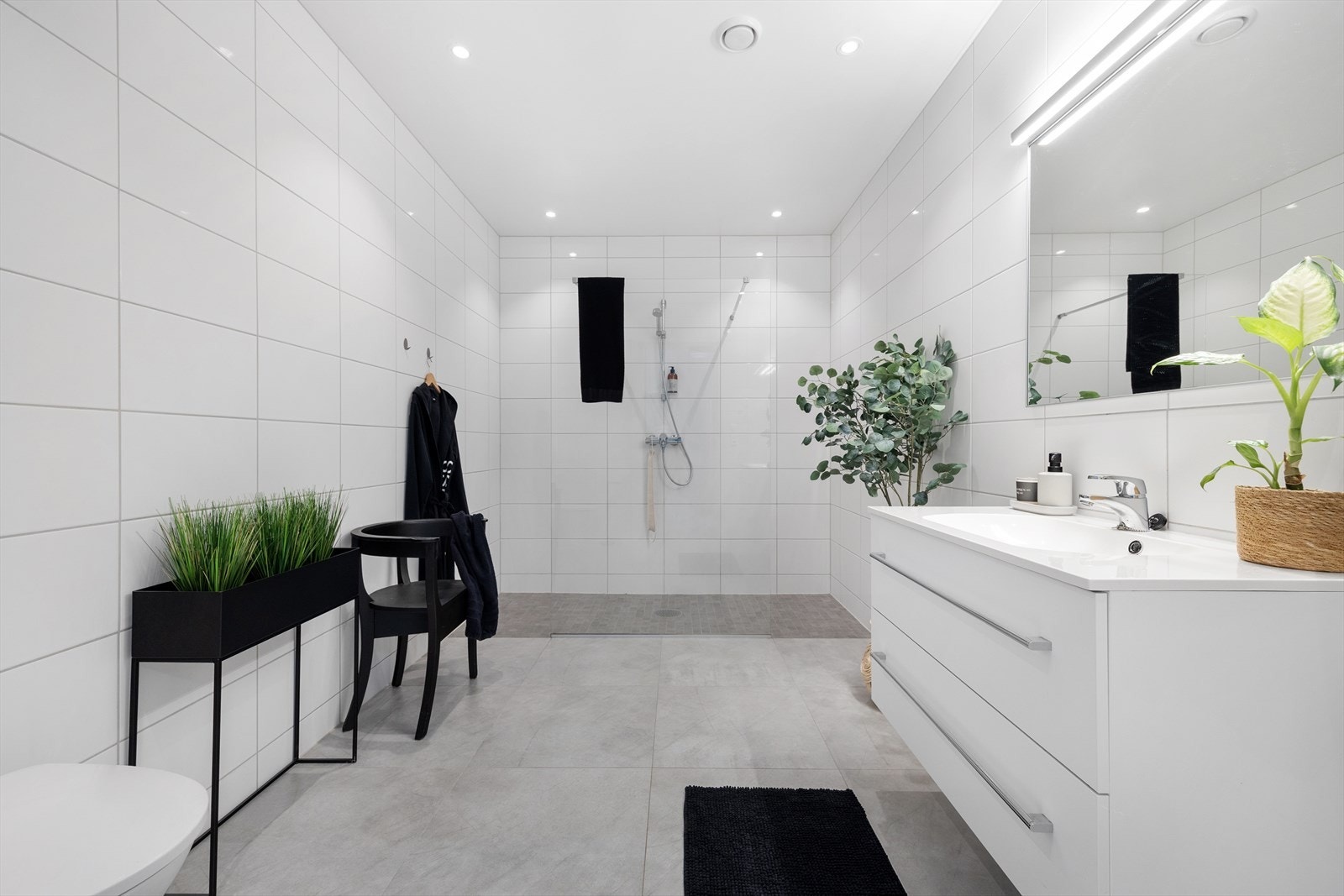 Stort helfliset baderom med moderne innredning og dusjsone Galleribilde