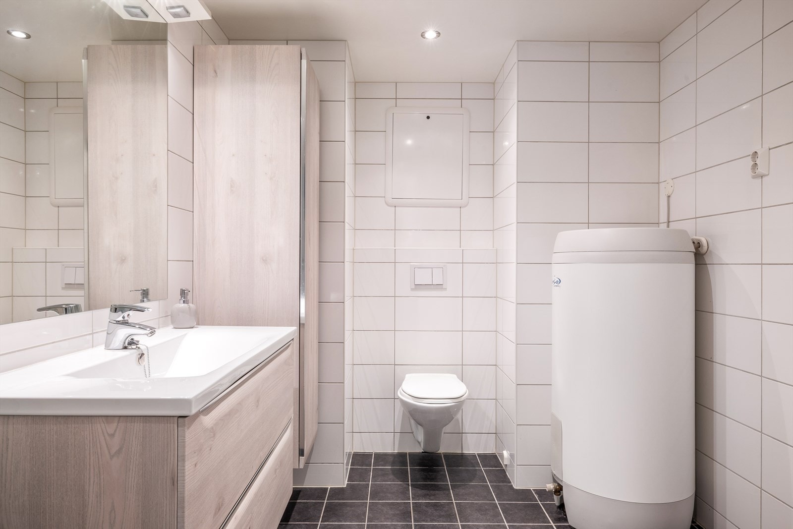 Badet er både moderne og romslig, og har fliser på både vegger og gulv Galleribilde