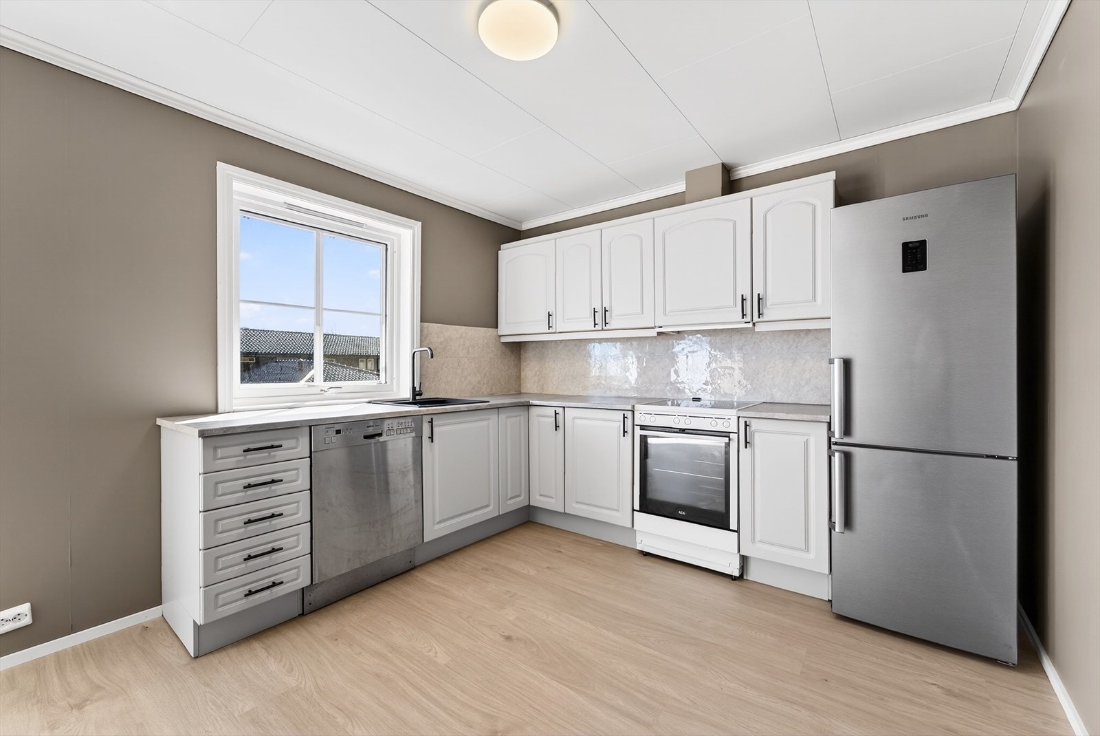 Profilert oppmalt kjøkken med enkeltstående hvitevarer som medfølger. Galleribilde