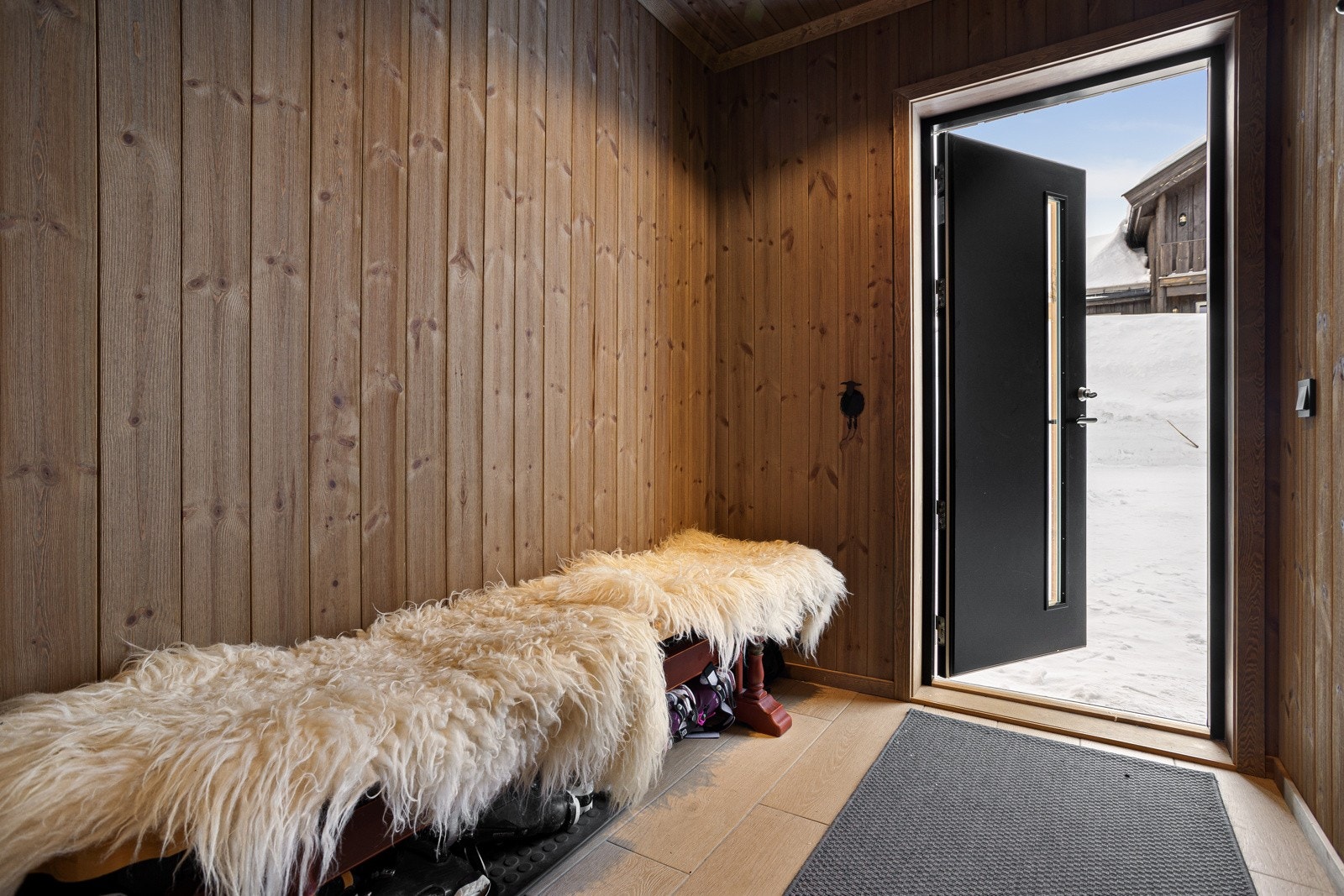 Man ankommer hytta via en pen, flislagt gang med varmekabler i gulv og downlights i himlingen Galleribilde