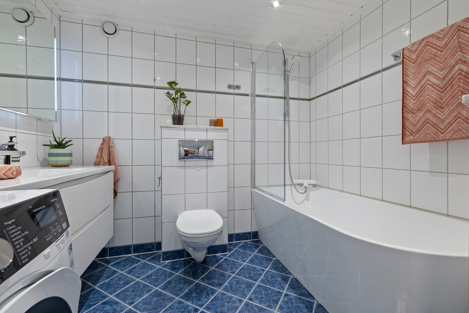 Badet har flislagte vegger og gulv, samt panel i himlingen Galleribilde