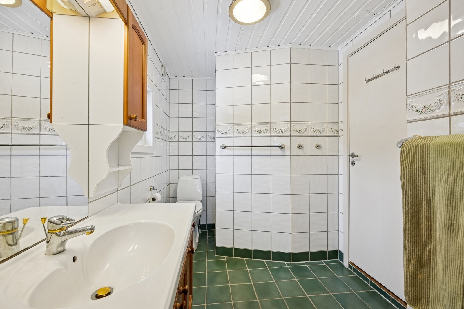 Romslig bad med varmekabler, toalett, servant, opplegg for vaskemaskin og dusj. Galleribilde