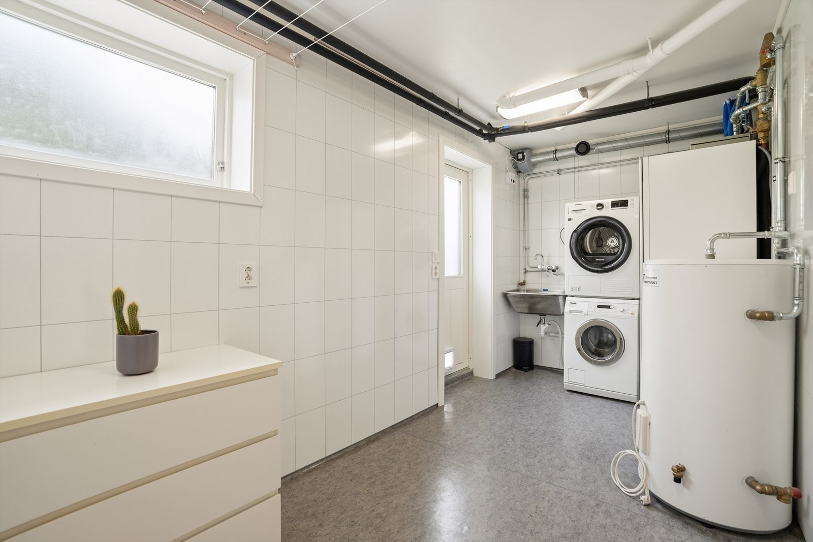 Praktisk vaskerom fra 2009 med gulvvarme, opplegg for vaskemaskin og egen utgang. Her står også bergvarmepumpen. Galleribilde