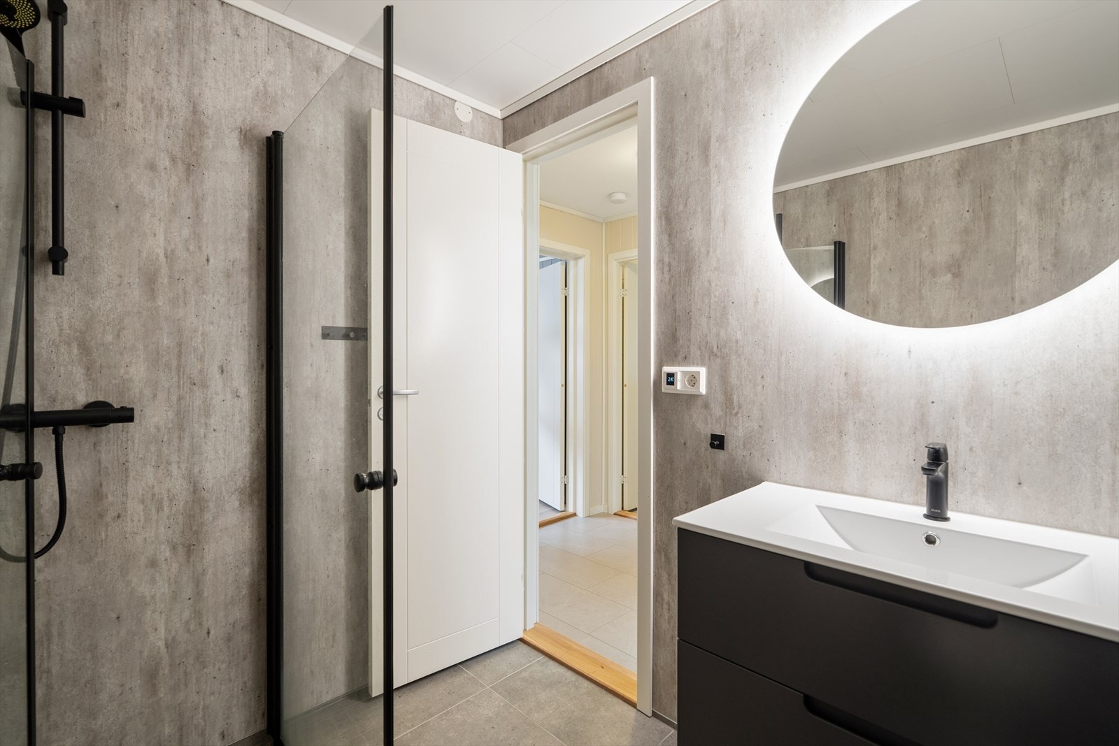 Rommet har dusjhjørne med nedsenket gulv, servantinnredning og mekanisk avtrekk. Galleribilde