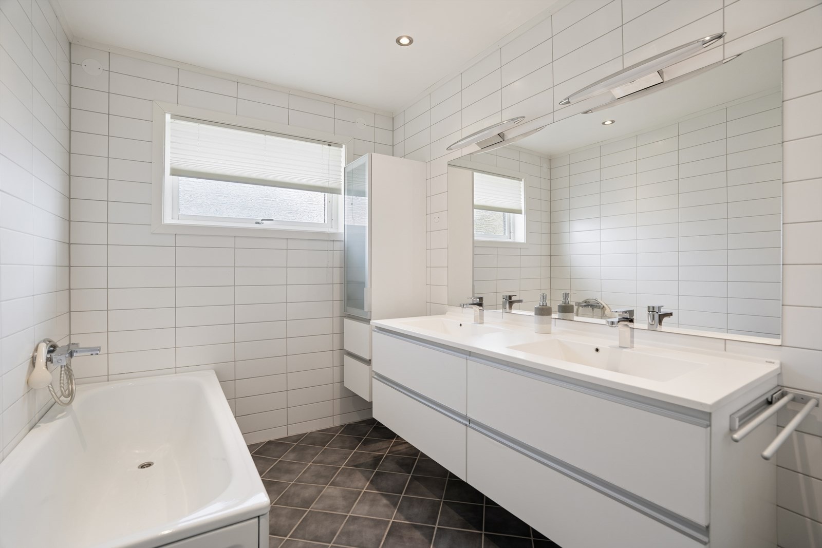 Badet i første etasje ble oppgradert i 2009. Det har flislagt gulv med varme, badekar og innredning med dobbel servant. Galleribilde