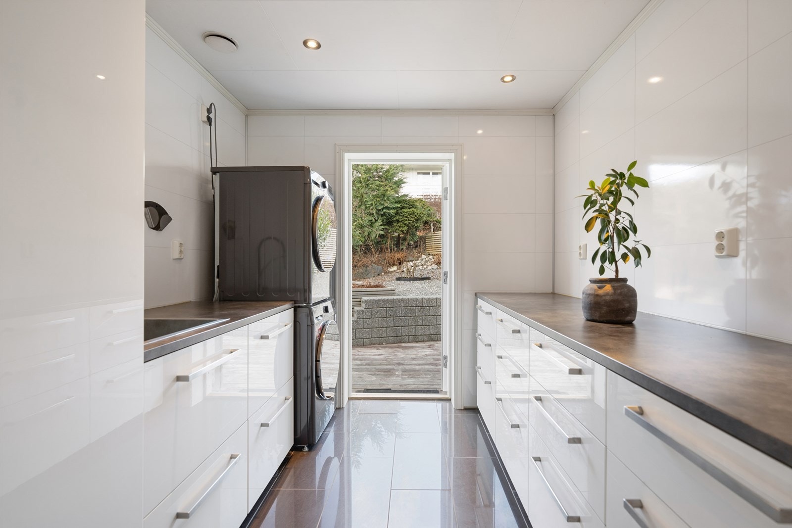 Praktisk vaskerom fra 2015 med vannbåren gulvvarme, rikelig med skapplass og egen utgang til nordsiden av eiendommen. Galleribilde