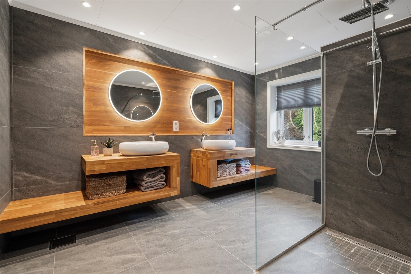 Hovedbadet, oppgradert i 2020, med innredning i eik fra Badnor, to servanter og et elegant, innfelt eikepanel. Galleribilde