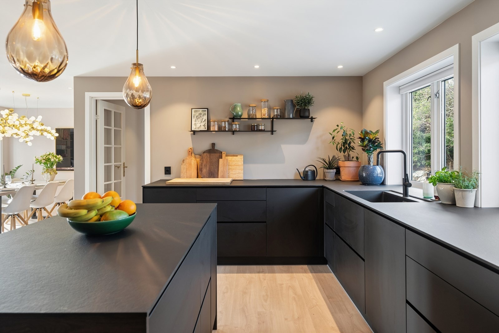 Innredningen har glatte, mørke fronter og en slitesterk benkeplate i kompaktlaminat som gir rikelig med arbeidsflate. Galleribilde