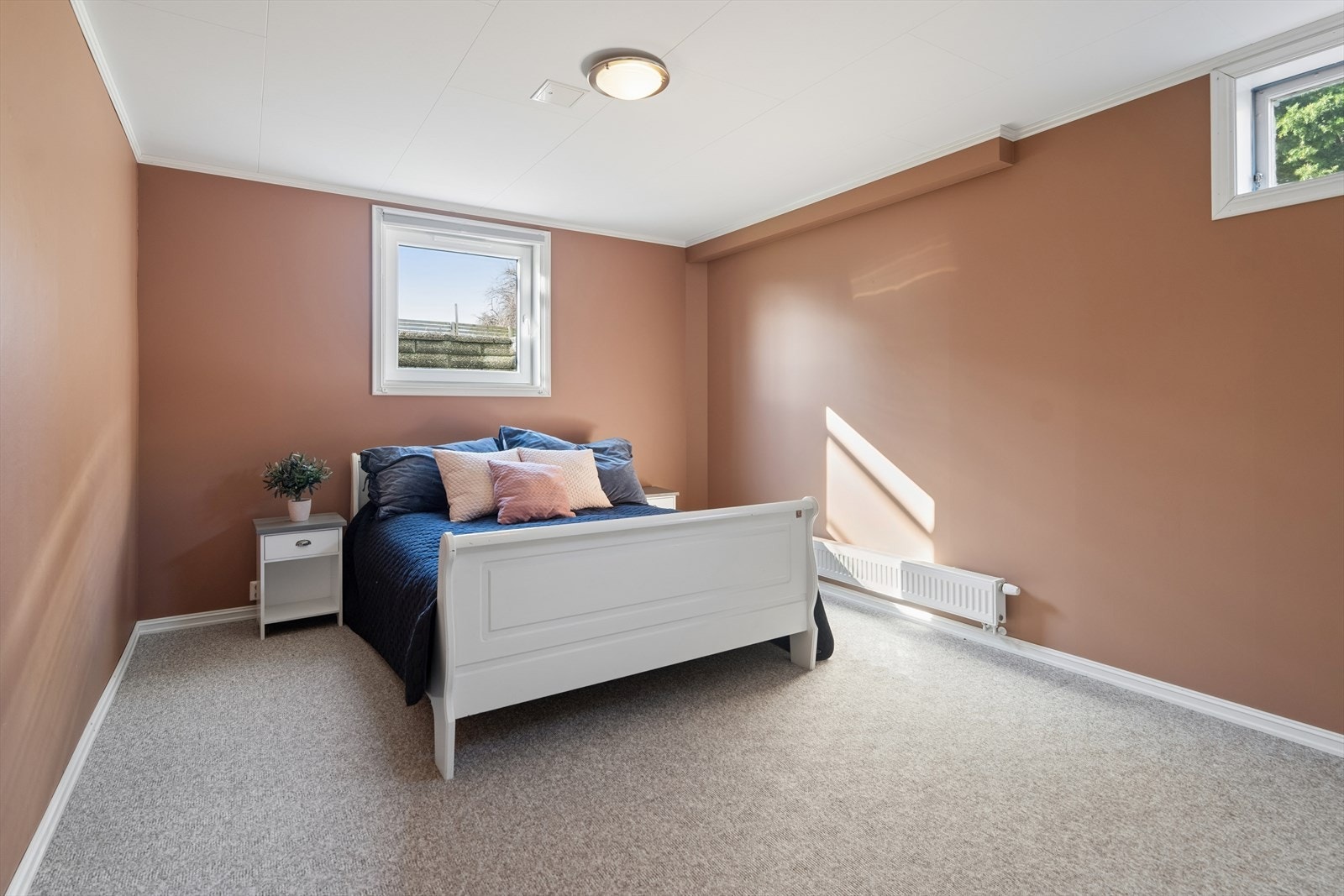 Det andre soverommet i kjelleren har teppe på gulvet og malte, slette vegger. Galleribilde