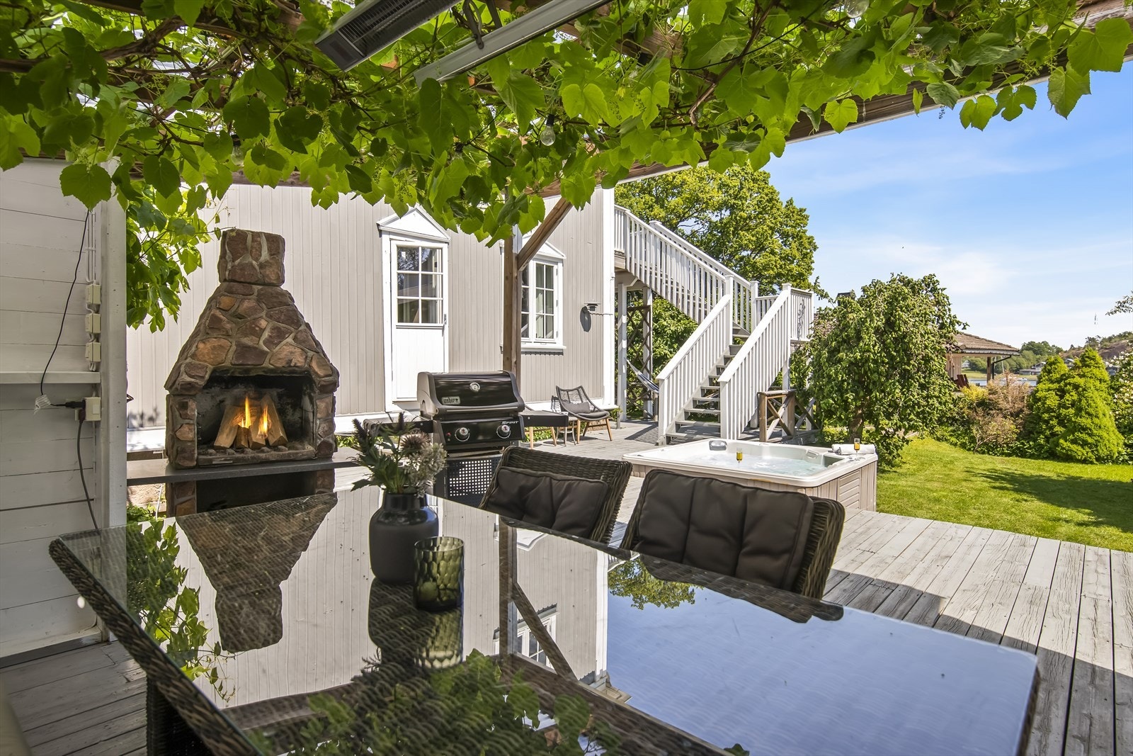 Tomtens hjerte er utvilsomt den store terrassen på bakkeplan. Her troner en flott pergola, kledd i grønt, som skaper en sjarmerende ramme rundt den plassbygde sittegruppen. Galleribilde