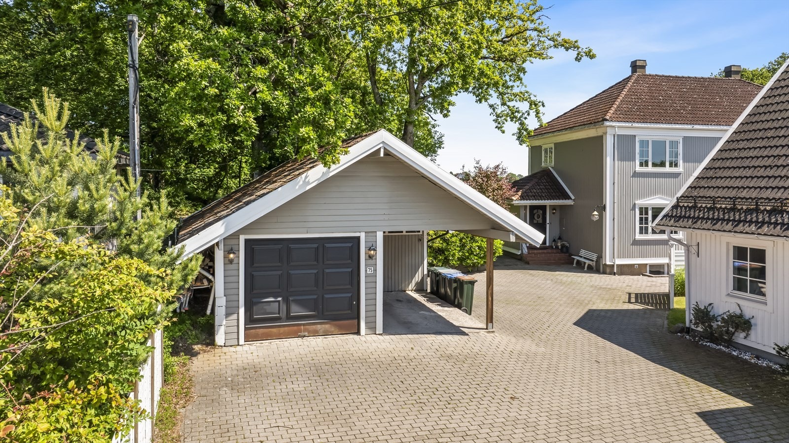 Allerede ved ankomst møtes du av en stor og innbydende innkjørsel med elegant belegningsstein, som har god plass til flere biler. Med egen garasje og en praktisk carport er det rikelig med plass til både kjøretøy og oppbevaring. Galleribilde