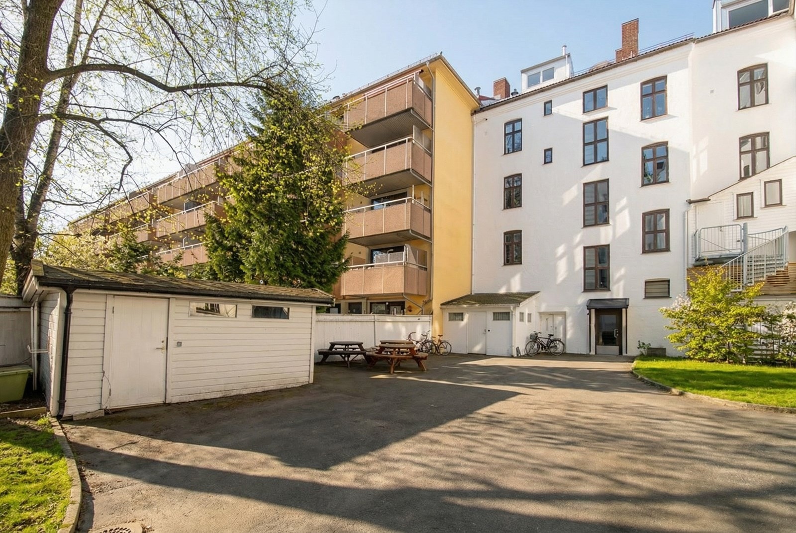 Grønn og frodig bakgård med hyggelige sitteplasser Galleribilde