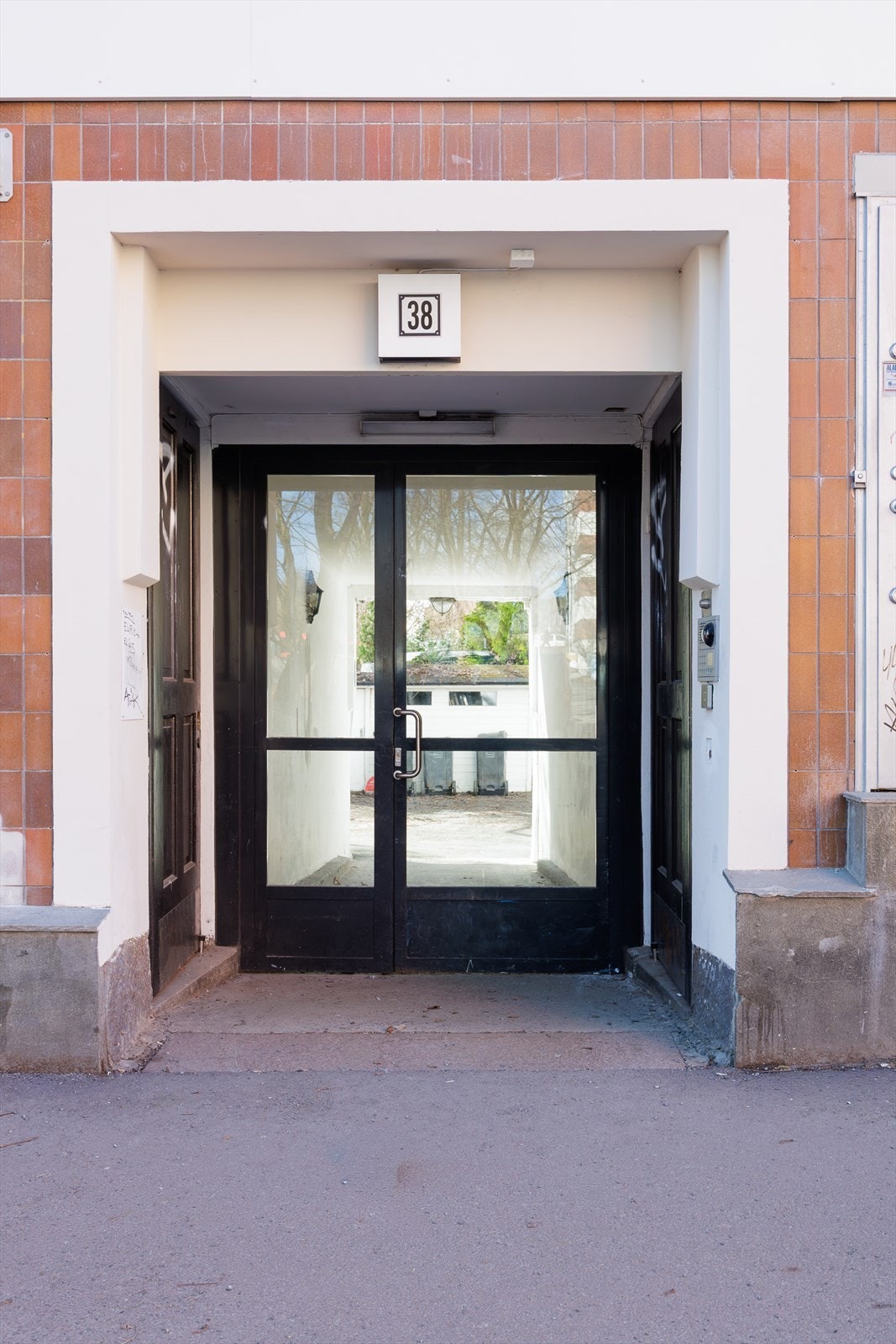 Inngangsparti fra gaten som leder deg inn til en rolig bakgård Galleribilde