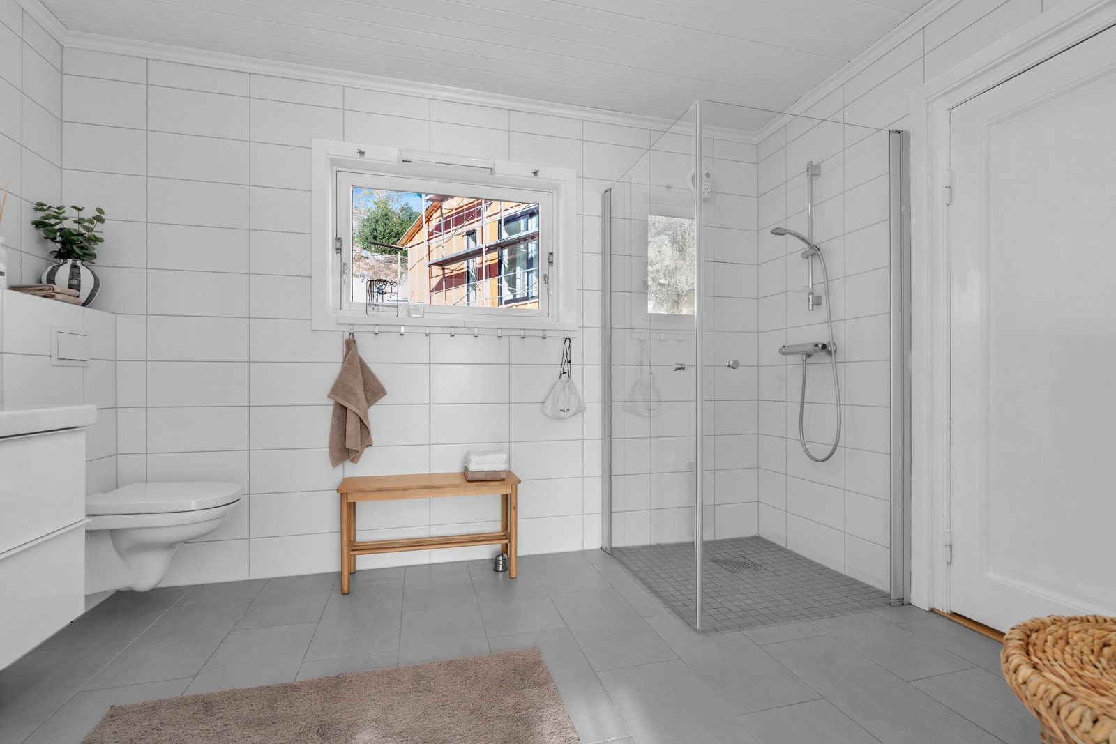 Moderne bad med blant annet dusjhjørne, vegghengt toalett og baderomsinnredning Galleribilde