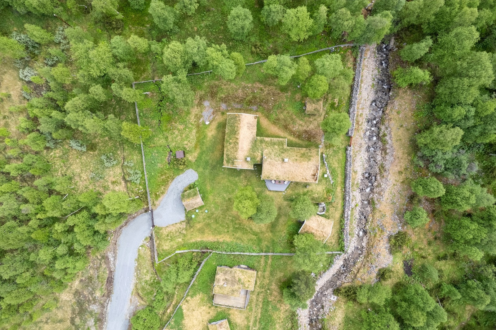 Bygningene er perfekt tilpasset tomten, og tunet rammes inn av skigard. Mot Storbekken er det laget mur i stein. Galleribilde