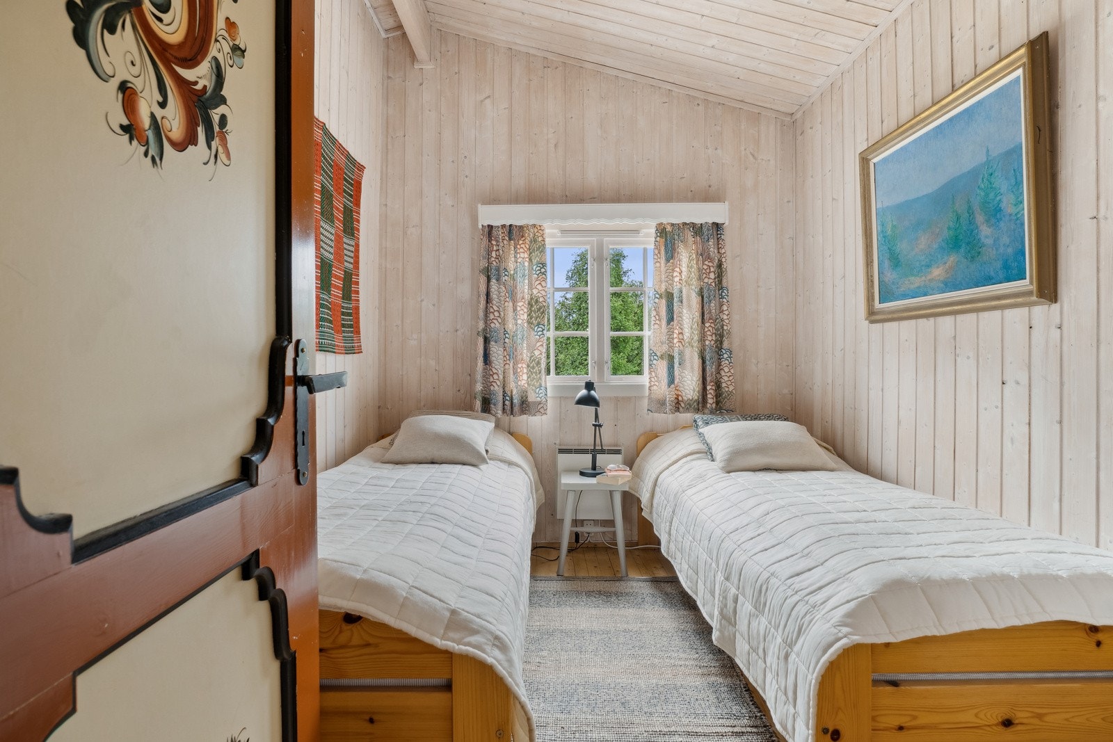 Det nest største soverommet i hoveddelen har plass til to senger. Legg merke til den fine rosemalingen på døren. Galleribilde