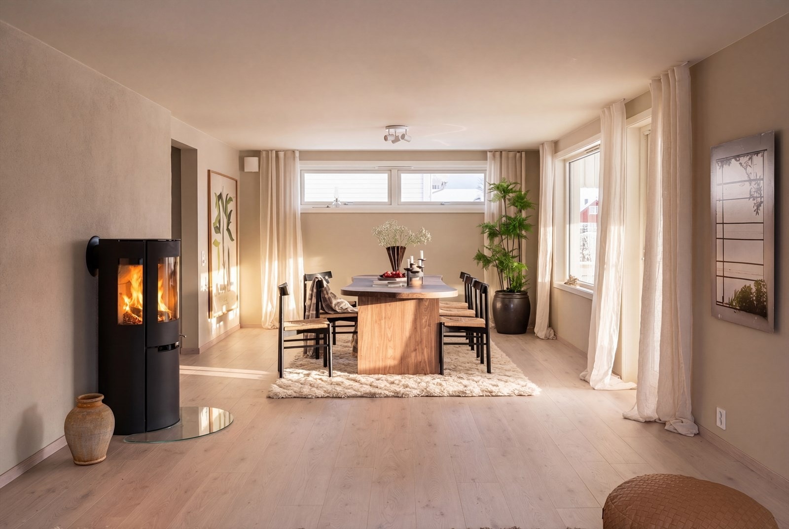 Stuen har ny peisovn med stort flammebilde, en varmepumpe og varmefolie i gulvet. Galleribilde