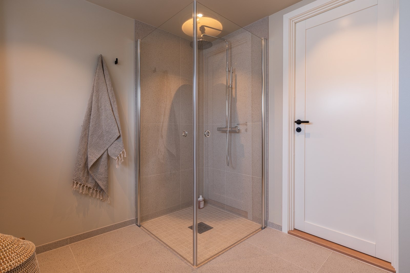 Badet er utført med storformatfliser på gulvet, gulvvarme, downlights og høytsittende vindusrekke. Galleribilde