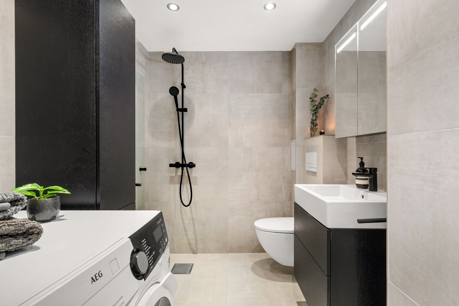 Stilrent og lekkert bad med store veggfliser fra Bergersen, baderomsmøbler fra Gustavberg samt dusjarmatur og kran fra Hans Grohe. Galleribilde