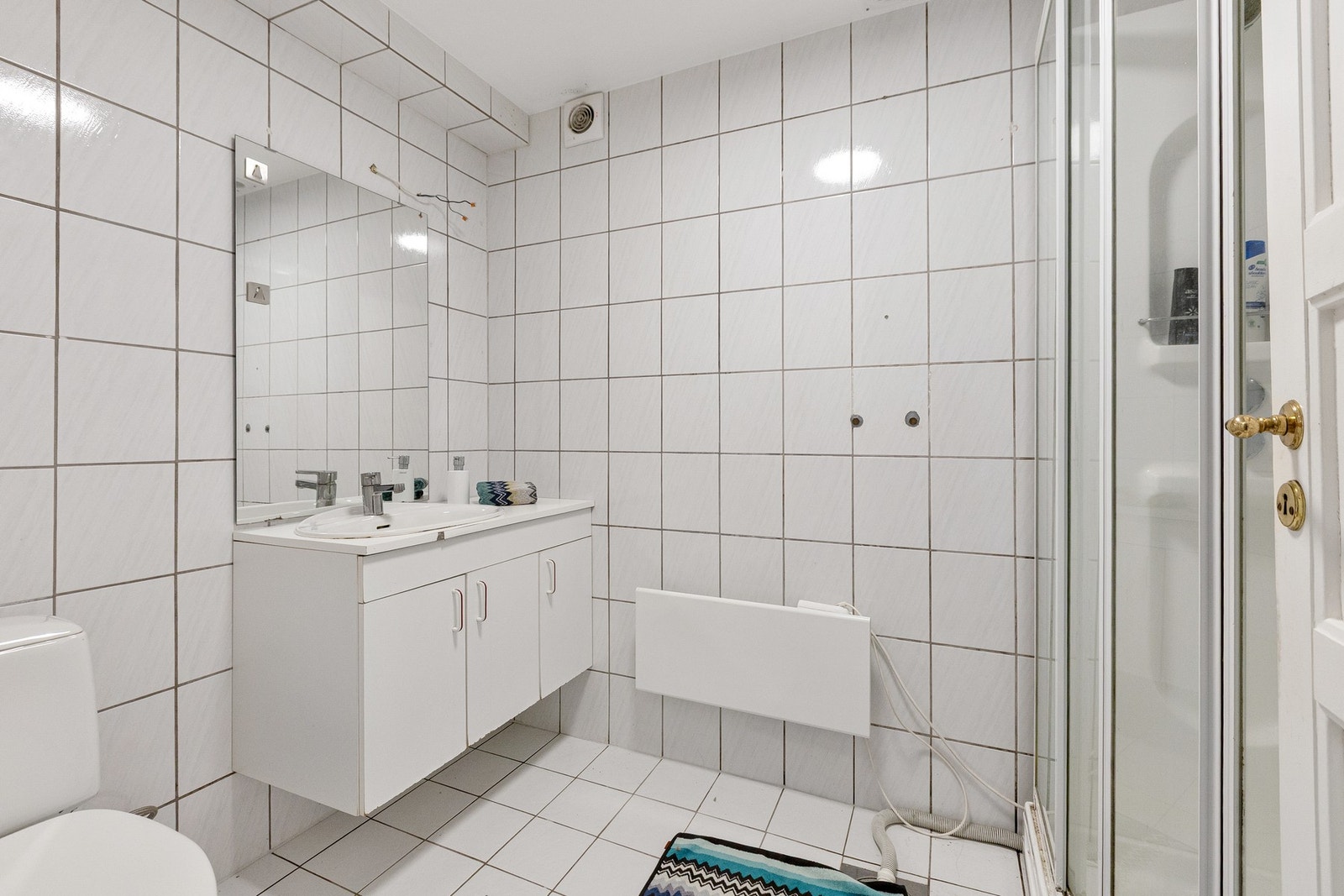 Vegghengt servantinnredning og ovenpåliggende servant med armatur. Mekanisk avtrekk med ventil i himling og opplegg for vaskemaskin. Galleribilde