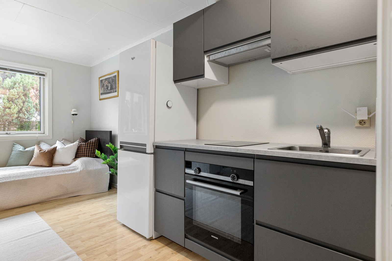 Åpen kjøkkenløsning innredet fra 2020 med glatte fronter. Frittstående kjøleskap med fryser, integrert stekeovn og platetopp. Galleribilde