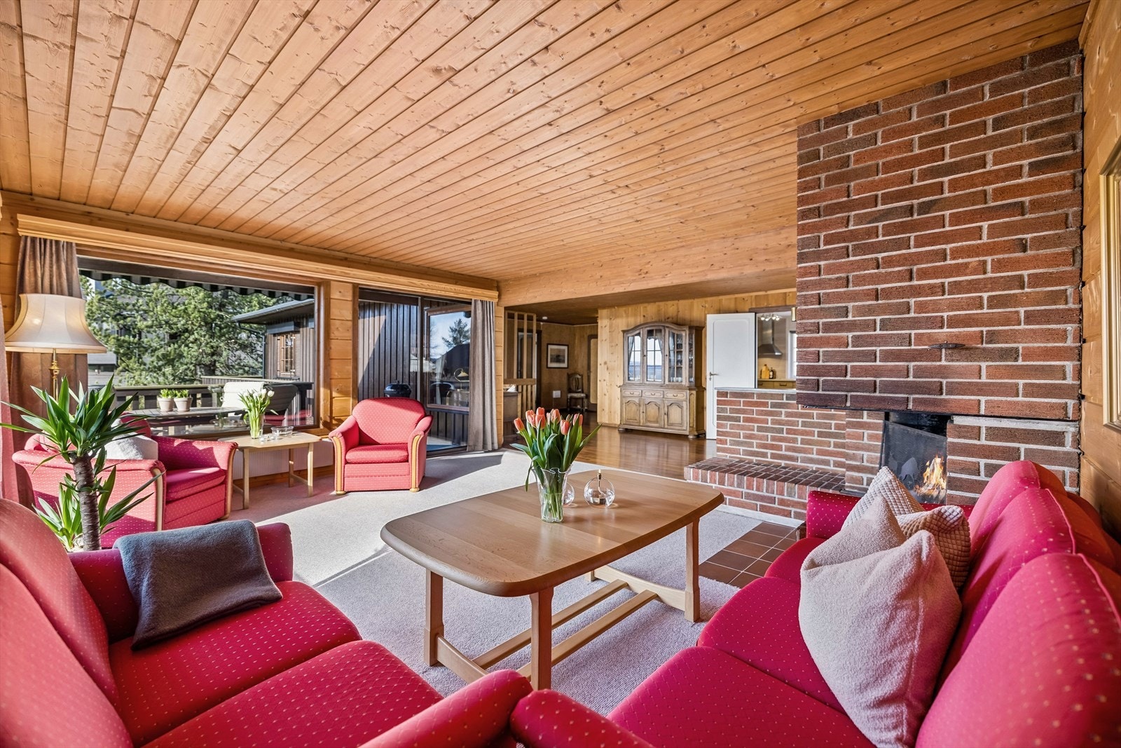 Den åpne peisen med omramming av murte teglsteiner er et sentralt element i stuen. Galleribilde