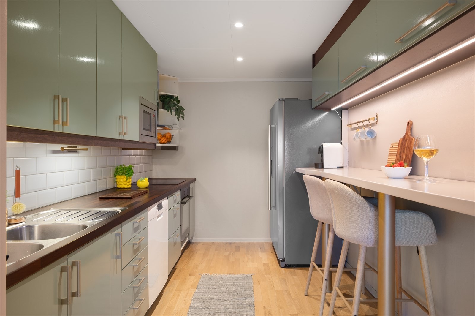 Pent kjøkken med med glatte fronter og laminat benkeplate. Galleribilde