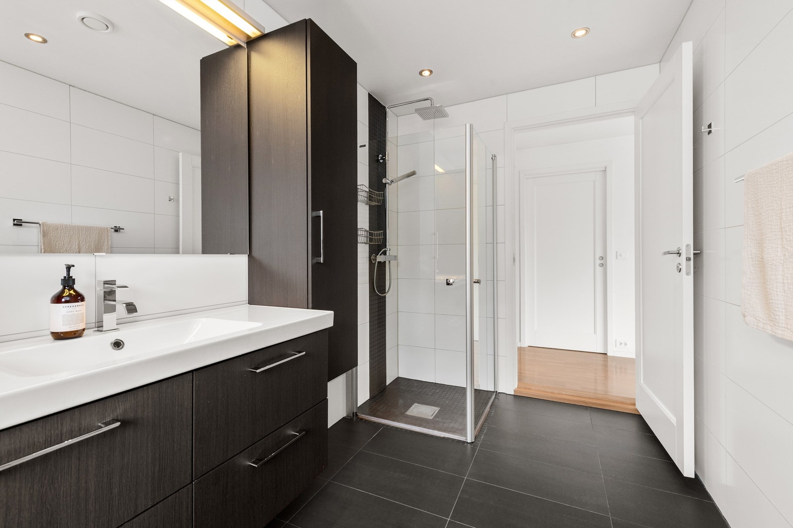 Badet har dusjhjørne med både hånddusj og regndusj, samt god oppbevaringsplass i veggmonterte skap. Galleribilde