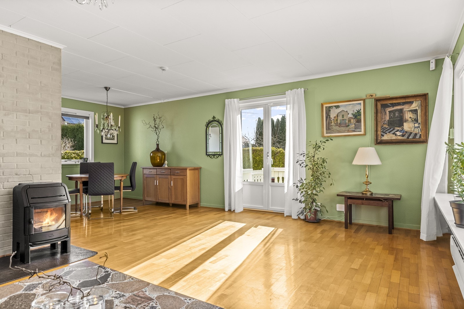 Fra stuen er det direkte utgang til verandaen og videre til en hyggelig uteplass og frodig hage - perfekt for avslapning og sosiale sammenkomster. Galleribilde