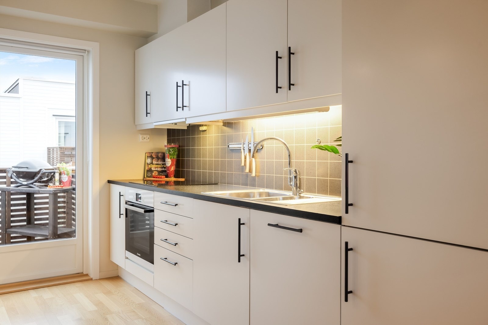 Kjøkkenet har integrerte hvitevarer som stekeovn, platetopp, oppvaskmaskin og kjøleskap med fryser. Galleribilde