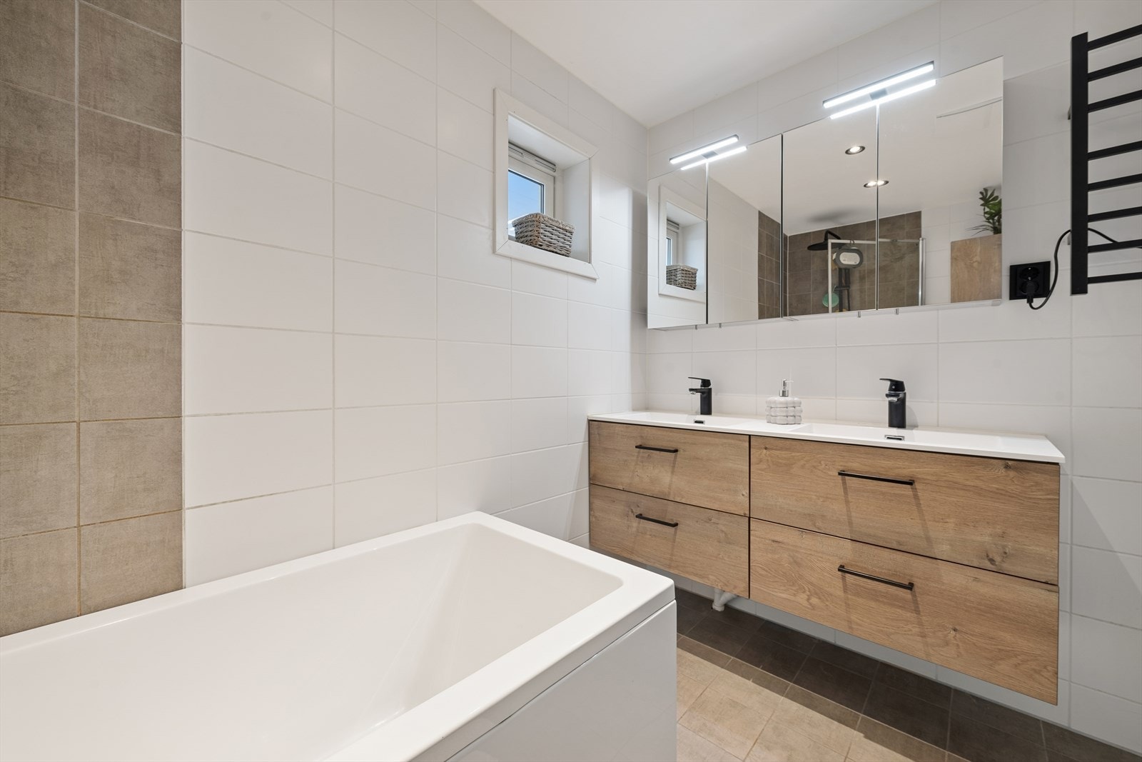 Badet har dobbelt vegghengt servantskap med heldekkende dobbel servant og ett-greps armaturer. To vegghengte speilskap med belysning. Galleribilde
