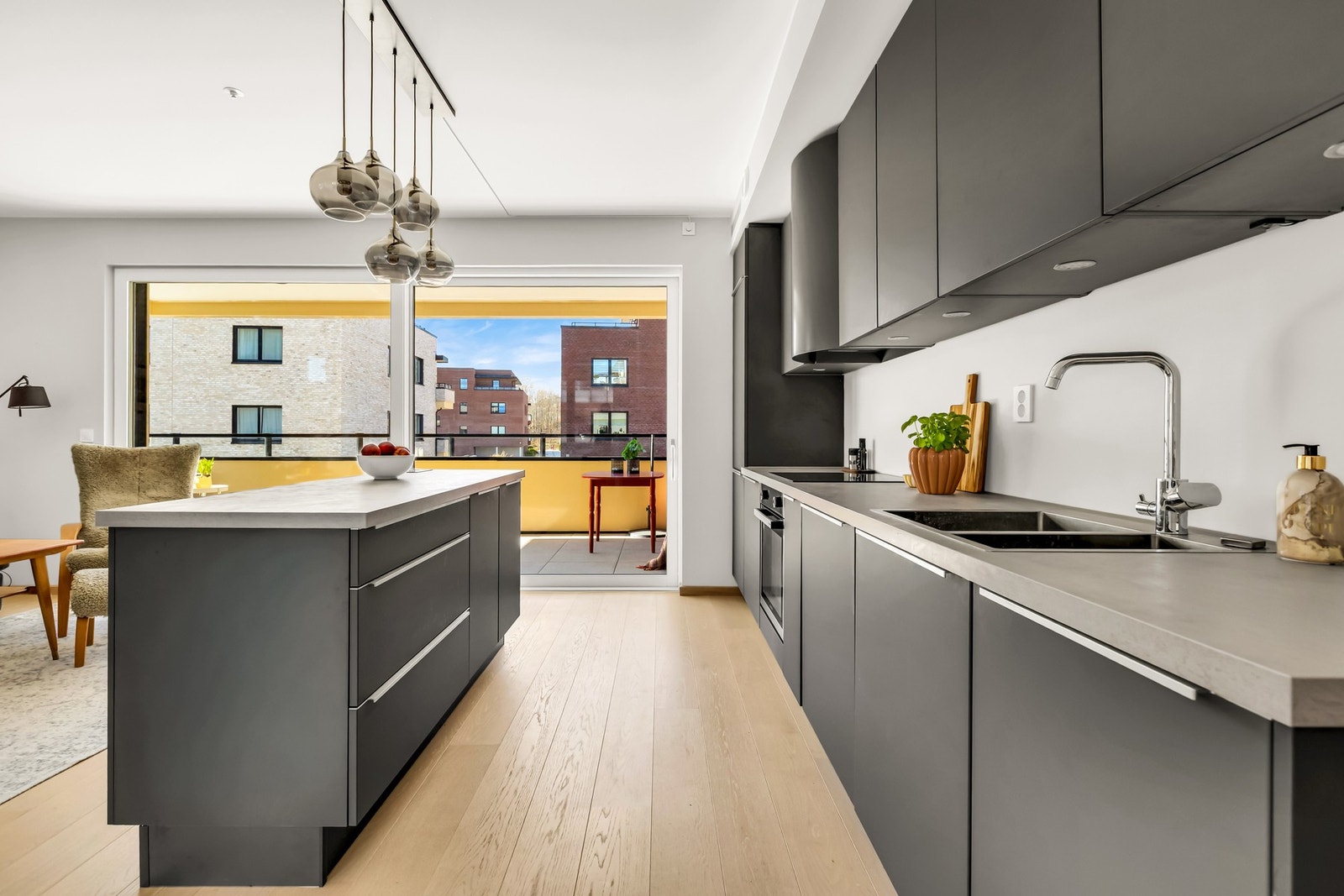 Stilrent kjøkken med glatte fronter og integrerte hvitevarer fra byggeår Galleribilde