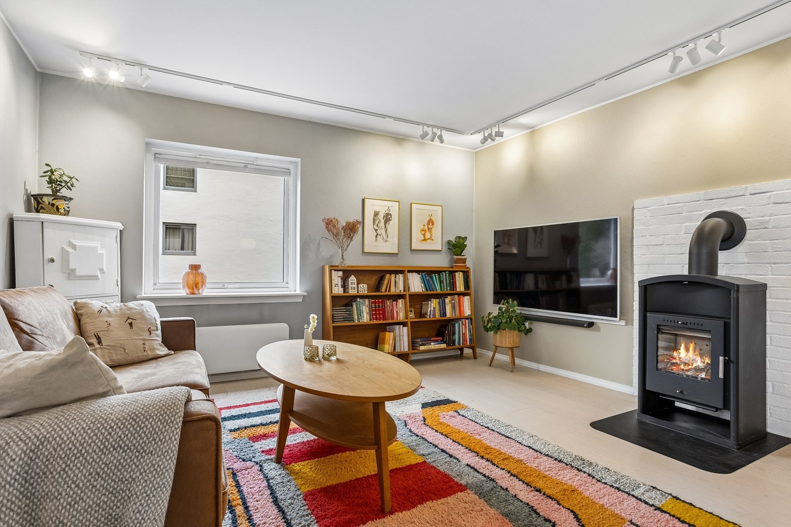 Stuen på 21 m² har parkett på gulvet og en vedfyrt ovn som gir lun varme. Galleribilde