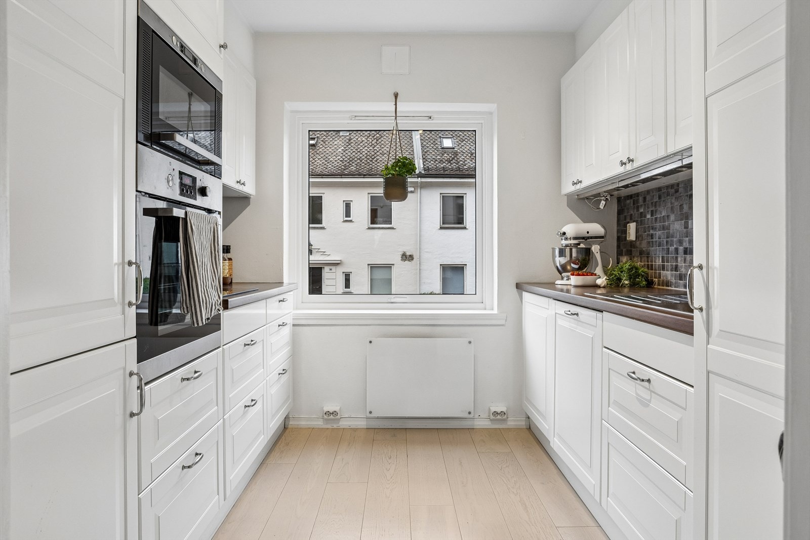 Kjøkkenet har en praktisk parallell-løsning med integrert stekeovn, platetopp og rikelig med skapplass. Galleribilde