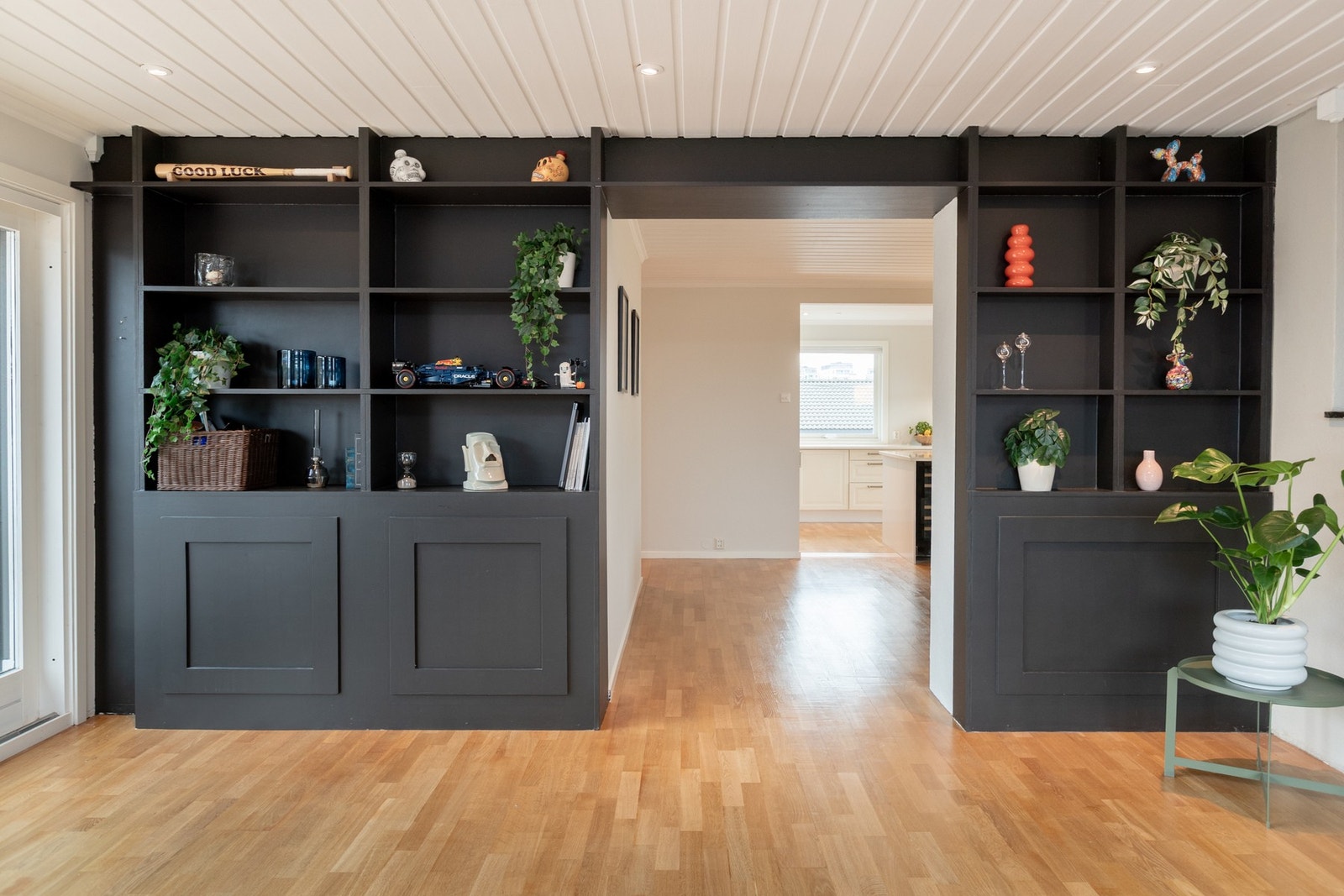 Kul hylleløsning mellom stue og kjøkken - tydelig avgrensning mellom sonene - samtidig som det fremdeles oppleves åpent og tilgjengelig. Galleribilde