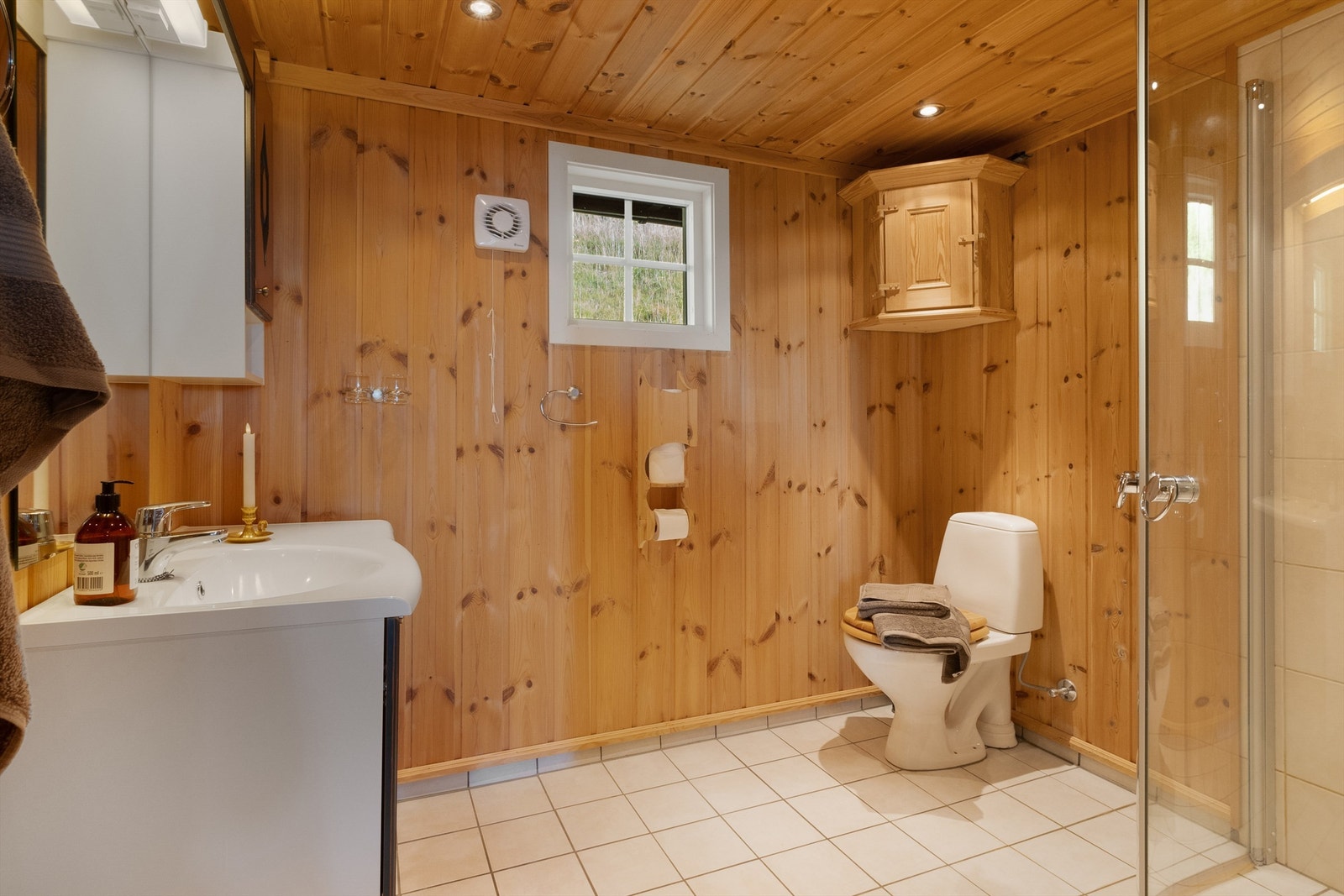 Her er det både toalett, dusjhjørne med glassdører og vegghengt servant med innredning. Galleribilde