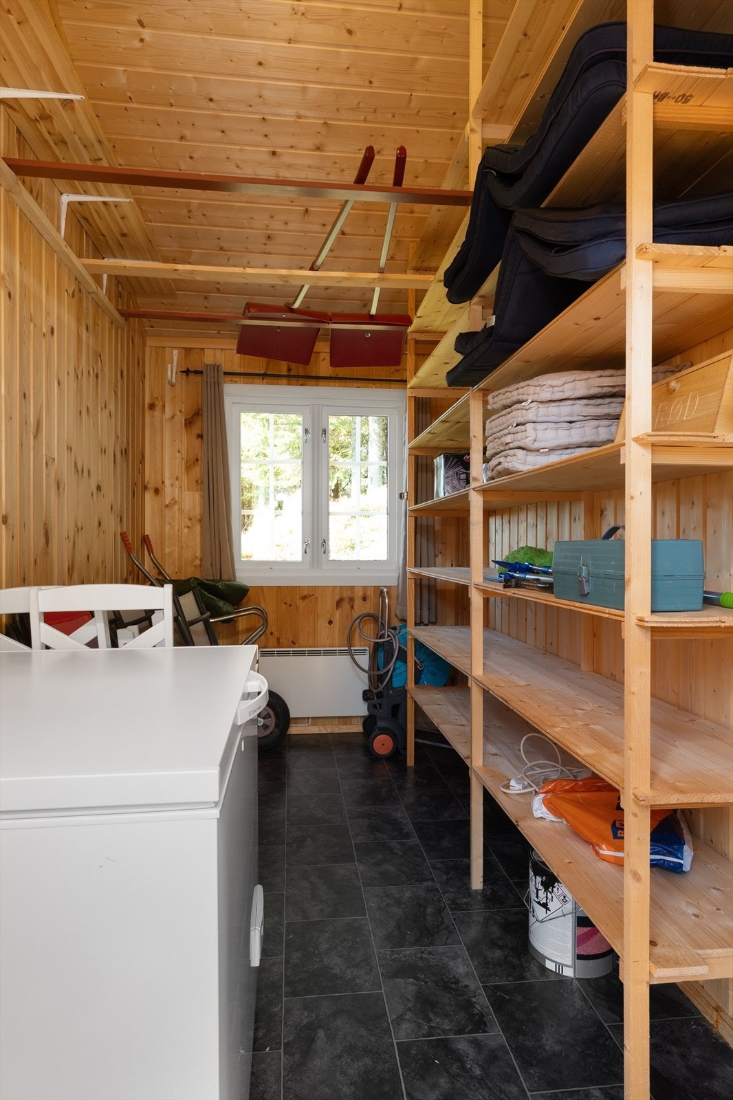 Den andre delen av annekset er innredet som bod. Her er der montert hjemmelagde hyller, oppbevaring til redskap og plass til en ekstra fryser for eksempel. Galleribilde