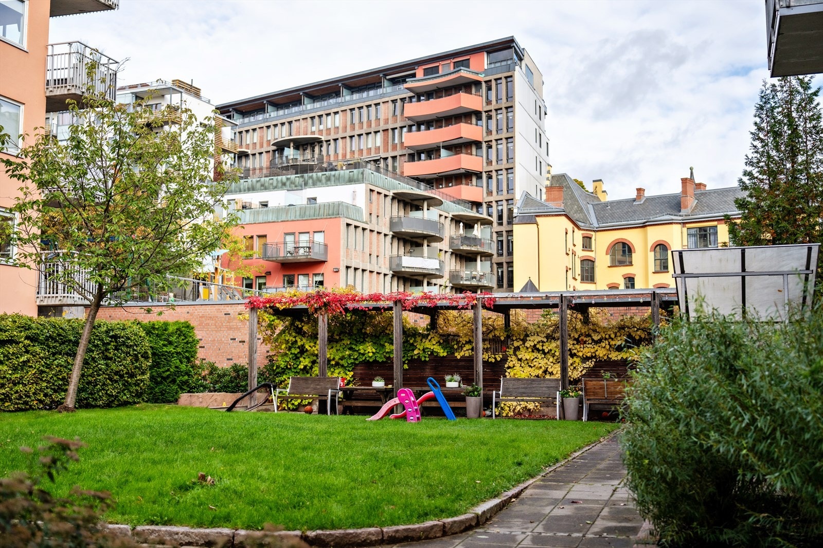 Fellesarealet byr på lekeplass og pergola i bakgården til glede for beboerne. Et svært barnevennlig område! Galleribilde