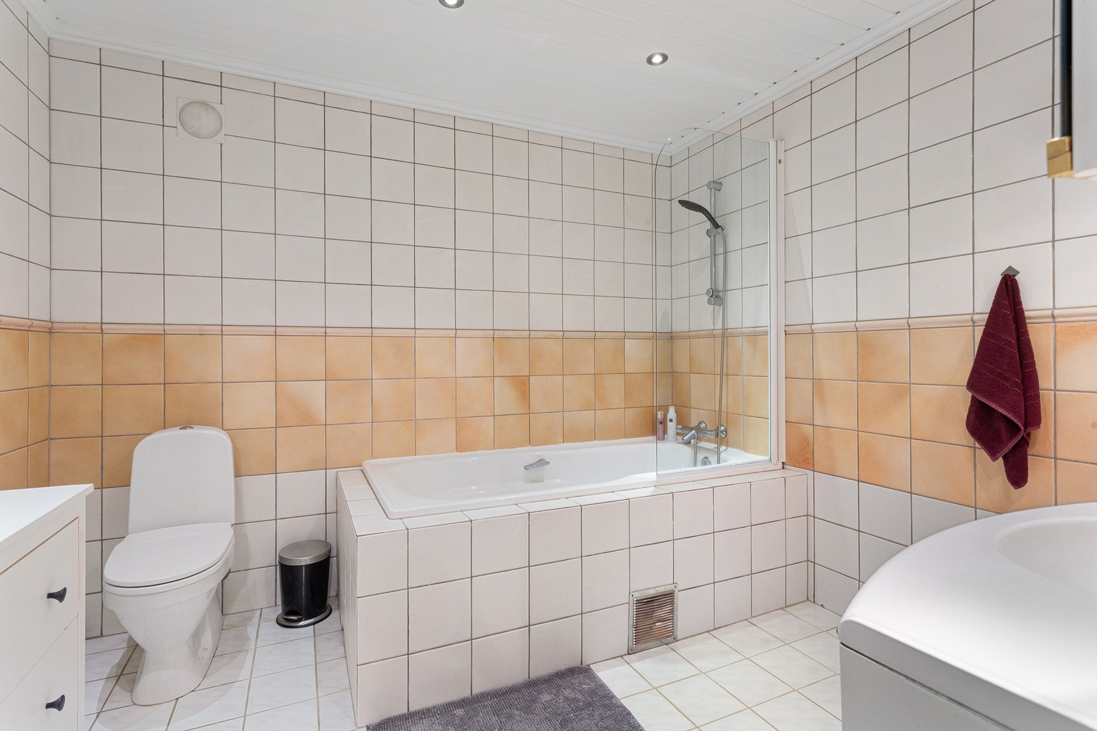 Flislagt bad med downlights i taket og dusjløsning i badekaret. Galleribilde