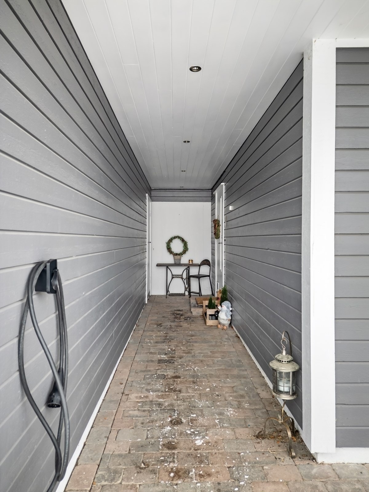 Overbygget inngangsparti i underetasjen med adkomst til boligen og en utvendig bod. Galleribilde