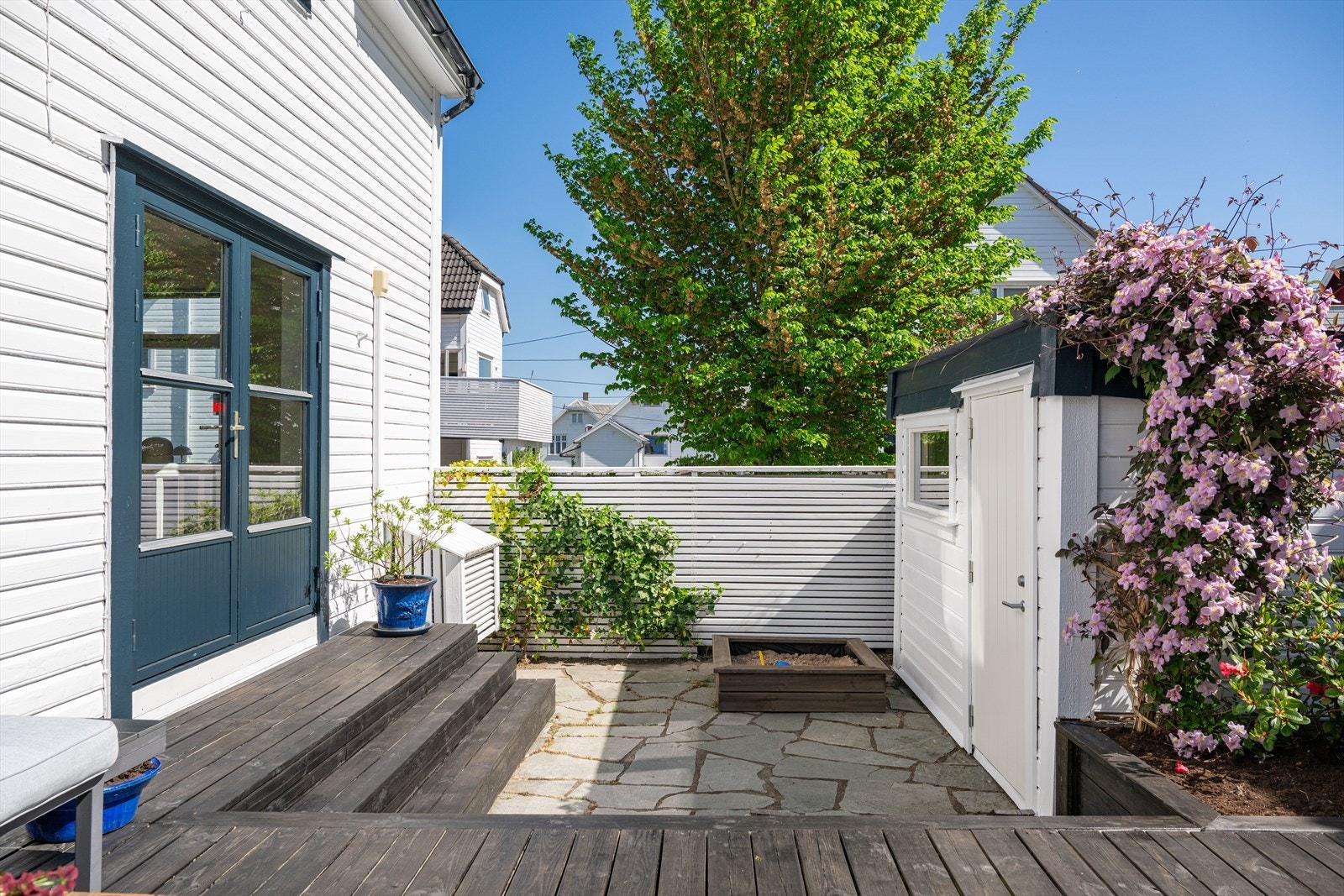 Uteområdet er skjermet og området er omkranset av frodig beplantning, blomster og små trær. Galleribilde