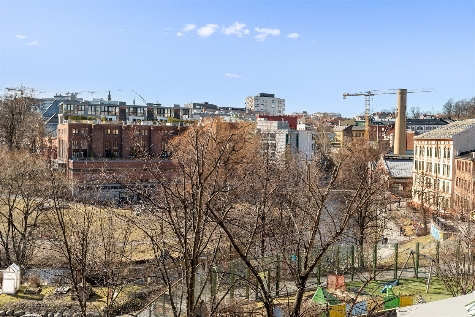 Utsikten fra leiligheten inkluderer både urbane elementer og åpne grøntområder, som skaper en variert opplevelse. Galleribilde