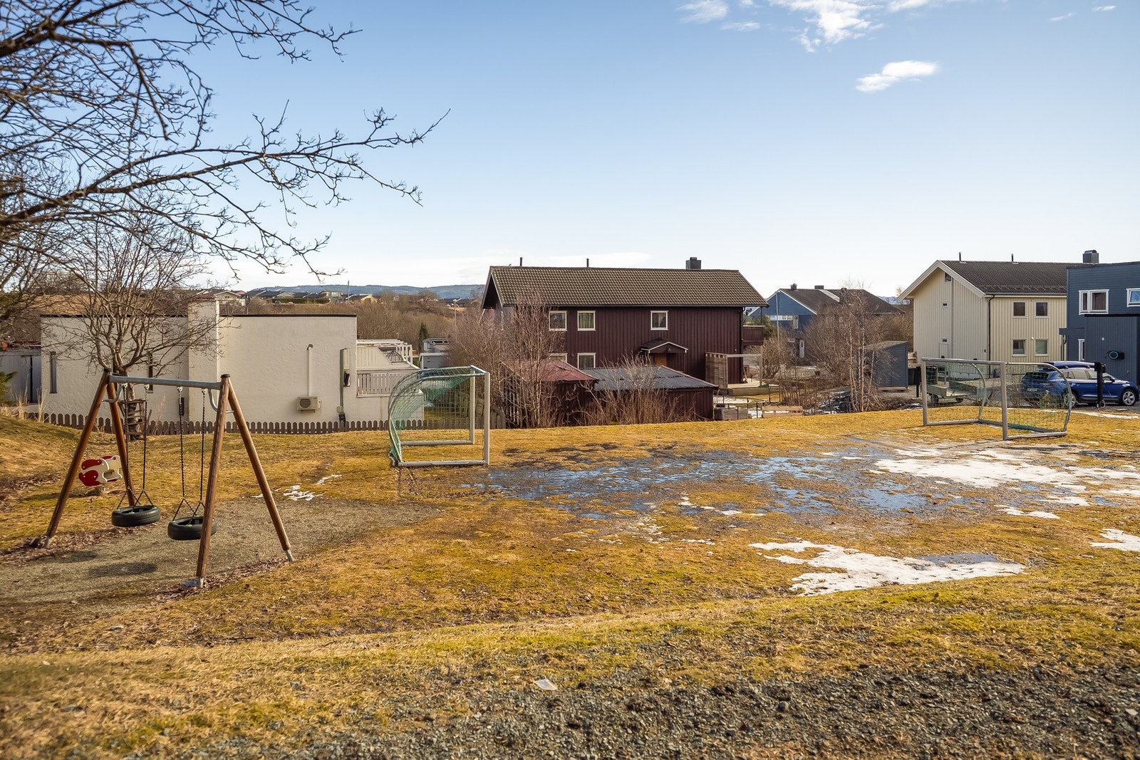 Lekeplass med disser og fotballbane rett over gaten. Galleribilde