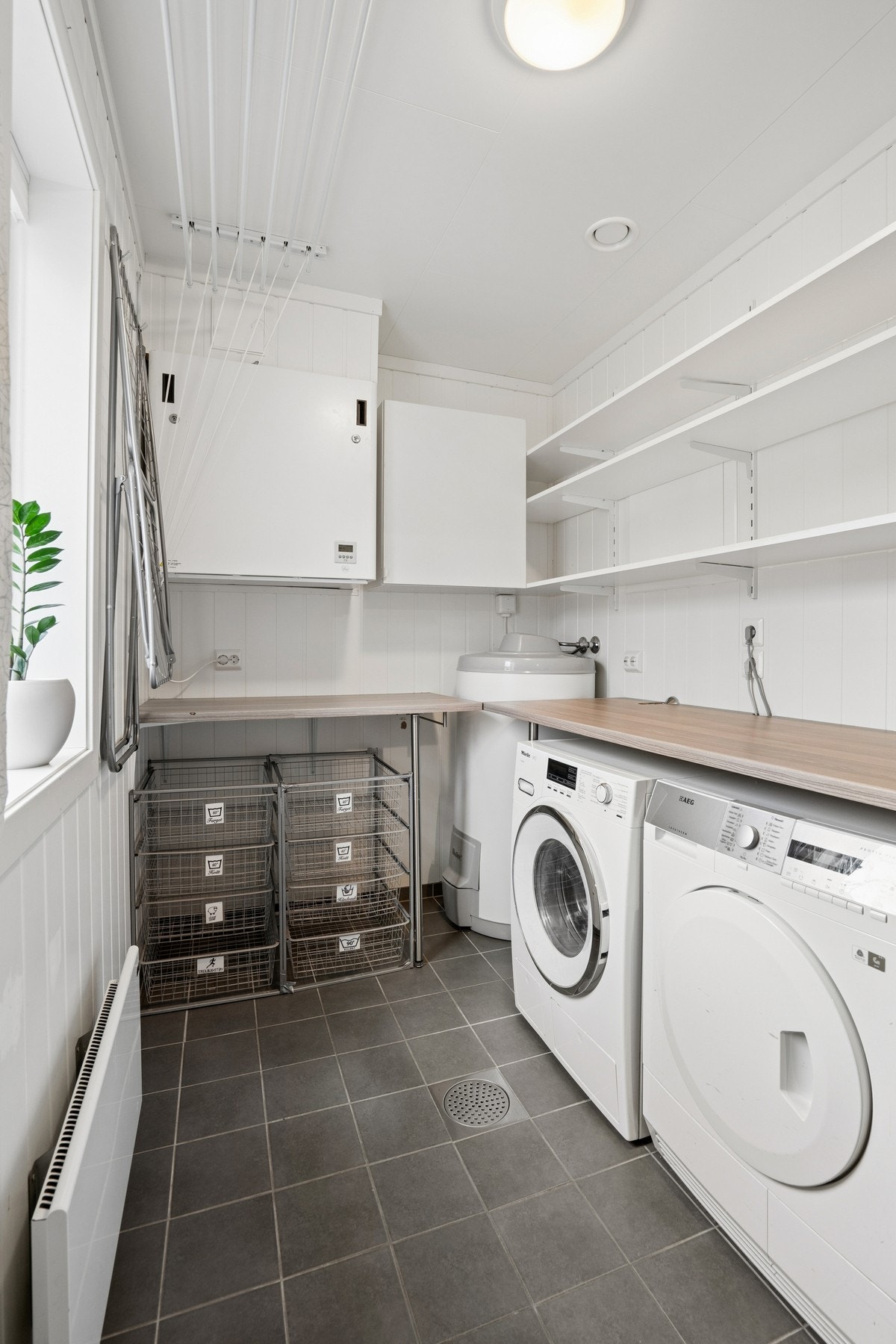 Teknisk rom med opplegg for vaskemaskin. Rommet byr også på ekstra oppbevaringsplass. Galleribilde