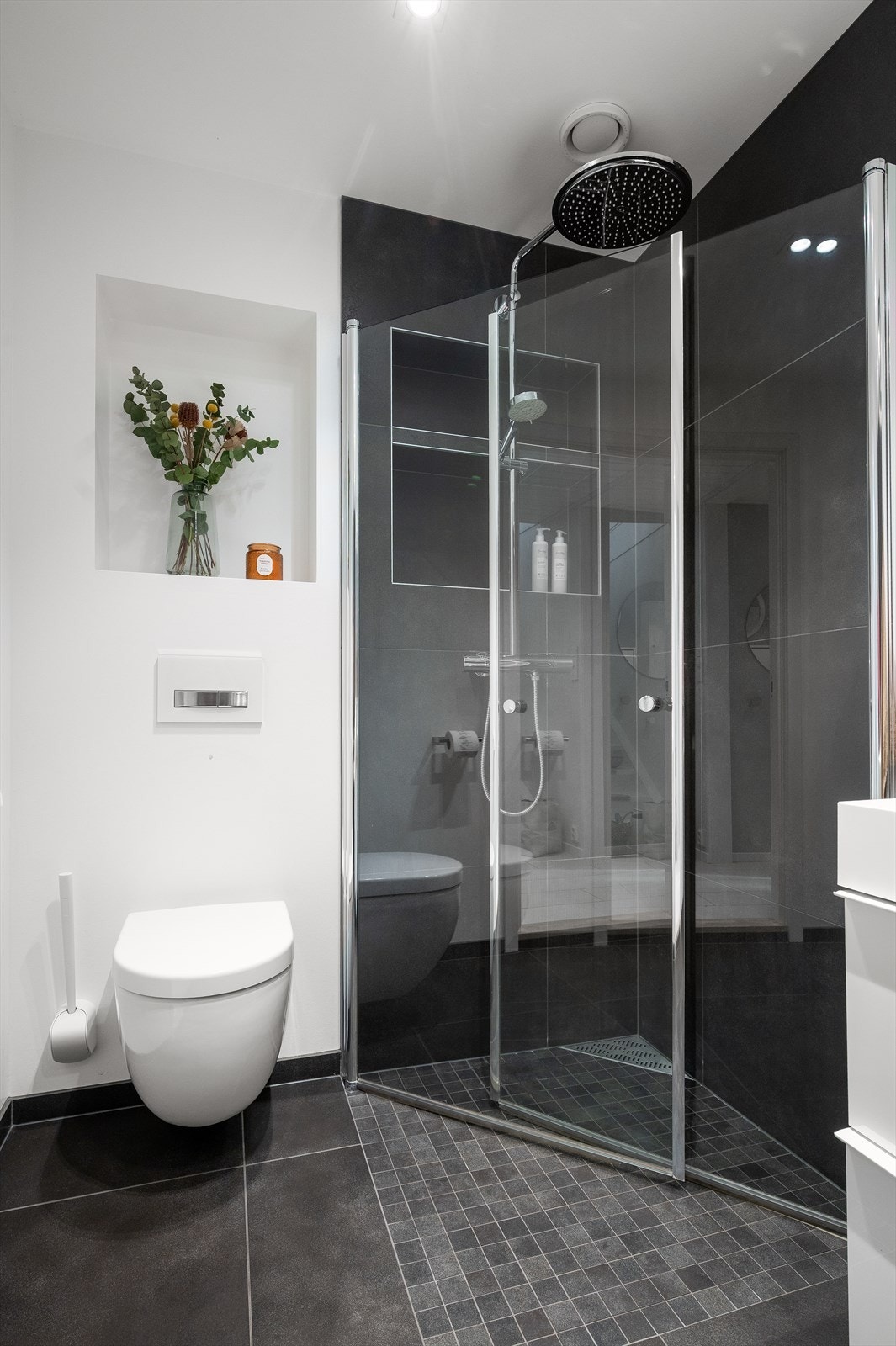 Badet har flislagt gulv med elektrisk gulvvarme, vegghengt toalett og dusjvegger. Galleribilde