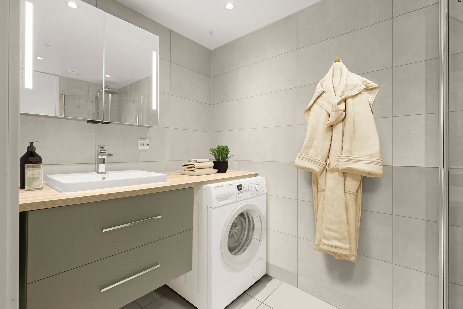 Badet er innredet med nedsenket dusjhjørne, vegghengt toalett, servant med skuffer, samt speil med integrert lys. Det er opplegg for vaskemaskin Galleribilde