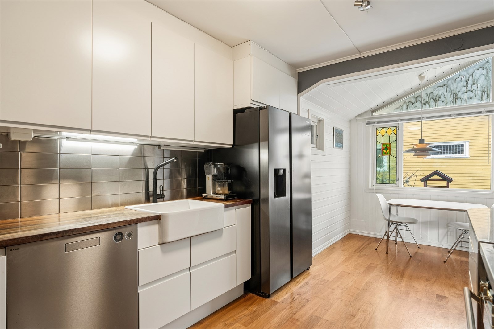 Kjøkkenet fremstår lyst og innbydende - Innredet med frittstående kjøl-/fryseskap, integrert oppvaskmaskin, platetopp og stekeovn. Galleribilde